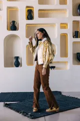 Campera oversize de cuero tostado con solapas y forro interno de corderito sintético azul marino, mangas anchas y detalles de costuras trenzadas.