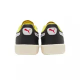Championes Puma modelo Palermo en colaboración con Ferrari, de diseño urbano con base negra, detalles en blanco y amarillo, y suela de goma en tono crema con acento rojo.