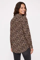 Camisa de manga larga con estampado animal print tipo leopardo, cuello camisero, cierre frontal con botones y bolsillo ojal en el pecho.