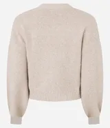 Cardigan corto de punto color beige claro, con escote en V, manga larga abullonada y cierre frontal de botones. Posee bolsillos delanteros tipo parche.