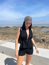 Conjunto de top halter y shorts negros con textura arrugada.