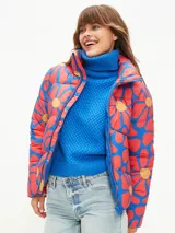 Campera puffer corta con estampado abstracto en tonos verde, naranja y azul. Tiene cuello alto, cierre frontal con cremallera y bolsillos laterales.