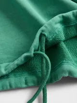 Buzo con capucha de corte holgado, color gris oscuro con efecto lavado, mangas largas con puños acanalados y cordón ajustable en el ruedo.