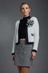 Falda corta de tiro alto con diseño de estampado pata de gallo en blanco y negro, confeccionada en tejido estructurado.