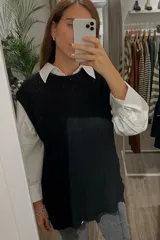 Chaleco tejido negro con tajos laterales.
