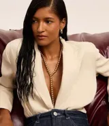 Conjunto de collar tipo lazo y aros tipo argolla, confeccionados en metal dorado con detalles de esferas.