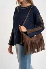 Sweater de tejido de punto con calce oversize, color azul marino con detalles en color marrón en las mangas y cuello. Presenta un diseño de manga larga y puños y ruedo acanalados.