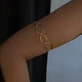 Brazalete dorado con diseño de eslabones entrelazados.