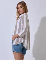 Camisa de algodón marca Dash, de diseño abierto con rayas verticales en tonos marrón y blanco, cuello con solapa, cierre frontal de botones y mangas tres cuartos.