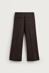 Pantalón de traje flare fit para hombre, confeccionado en tejido con lana, en color marrón oscuro. Presenta tiro medio, trabillas para cinturón, cierre frontal con cremallera y botón, bolsillos laterales y raya central marcada en las perneras.