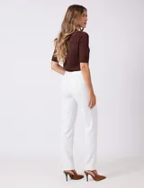 Pantalón sastrero de corte slim, color blanco, con pretina anatómica y panel interno modelador. Presenta bolsillos laterales tipo ojal, bolsillos traseros simulados y nervadura vertical marcada en el frente.
