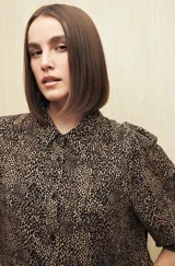 Camisa blanca con estampado lineal irregular en negro, de calce relajado, cuello clásico, abotonadura frontal y mangas largas con puños elastizados.