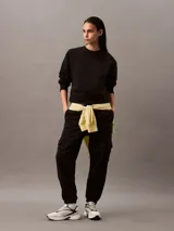 Pantalón de chándal negro de corte holgado con bolsillos cargo, cintura elástica y bajos elásticos. Confeccionado en felpa de mezcla de algodón.