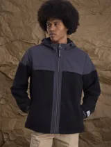 Campera con capucha confeccionada en una combinación de tejido técnico y sherpa, con cierre frontal completo y puños elásticos.