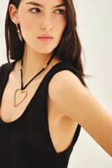 Top sin mangas de tejido de punto compacto con escote en U pronunciado. Presenta una textura sedosa y brillante, con un diseño ajustado al cuerpo.