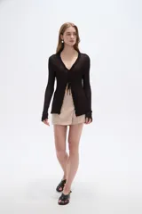 Saco abierto de viscosa color blanco, con cuello en V, lazo para anudar al frente y mangas largas con terminación ondulada.