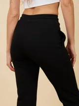 Pantalón deportivo tipo babucha color azul marino, de corte recto y tiro alto, con cintura elástica con cordón de ajuste y bolsillos laterales.