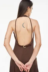 Vestido largo azul marino, de corte fluido, con escote halter, detalles trenzados en los hombros, bolsillos laterales y tajo profundo en la pierna.