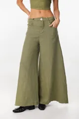 Pantalón de lino verde militar, de tiro alto y corte amplio con botamanga ancha. Cuenta con bolsillos delanteros aplicados y cierre frontal con botón y bragueta.