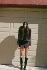 Chaleco de cuello subido y manga sisa, color marrón oscuro, con efecto pelo. Incluye bolsillos laterales ocultos en la costura y forro interior combinado. El cierre frontal es con ganchos metálicos forrados.