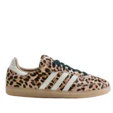 Championes Adidas modelo Samba OG W con diseño de estampado animal print de leopardo. Presenta las icónicas tres rayas laterales en color blanco, cordones oscuros y suela de caucho color caramelo.