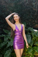 Vestido corto de fiesta color lila metalizado, con escote en V, breteles finos, cut-outs en la cintura y falda ajustada con cordones laterales.