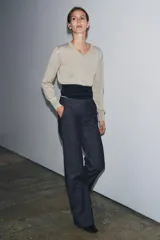 Jeans de tiro medio con corte flare y largo completo. Presenta bolsillos delanteros, cierre con cremallera, botón y ganchos metálicos.