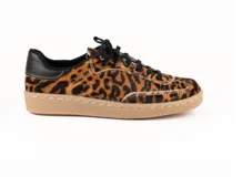 Zapatilla urbana de cuero con pelo estampado animal print de leopardo. Presenta cordones negros, detalle de cuero negro en el talón y suela cosida de goma en color tostado.