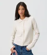 Saco de tricot color blanco con cuello polo, mangas largas y cierre frontal con botones.