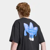 Remera Adidas de algodón color negro, con ajuste holgado, cuello redondo y moldería clásica de manga corta. Presenta un estampado gráfico frontal inspirado en el logo Trefoil con un diseño de personaje estilizado en tonos azules y blancos.