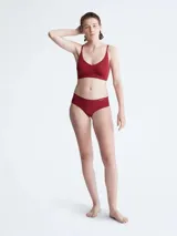 Bombacha tipo hipster de la colección invisible de Calvin Klein, confeccionada en microfibra ligera con bordes cortados a láser sin costuras. Presenta un diseño de talle bajo con cobertura total en la parte trasera y el logo de la marca estampado en la cadera.