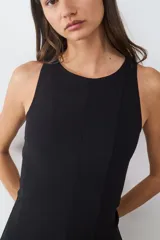 Vestido corto sin mangas con cuello redondo, diseño entallado en el torso y falda con vuelo tipo peplum. Cuenta con cierre invisible en la espalda.