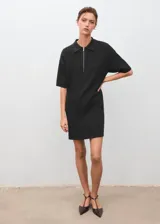 Vestido corto de tejido de punto fino color negro, con cuello polo y cierre frontal de cremallera, mangas corta y diseño recto.