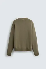 Jersey de corte relajado confeccionado en tejido de algodón. Presenta cuello redondo, manga larga y acabados en rib en puños, cuello y bajo.