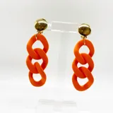 Aros colgantes con forma de cadena gruesa color naranja, con cabezales dorados y ajuste con clip.