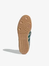 Zapatillas Adidas Samba LT plateadas con detalles en verde oscuro, suela de goma color caramelo y lengüeta plateada.