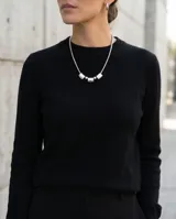 Collar de acero de cadena tipo serpiente con diseño frontal compuesto por tres piezas cilíndricas intercaladas por dos esferas metálicas.