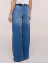 Jean pull on de tiro alto, color azul oscuro, con perneras amplias estilo wide leg, cintura elastizada en la espalda y bolsillos delanteros tipo parche con pespuntes contrastantes.