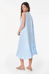 Vestido midi celeste de lino italiano, sin mangas, con escote redondo y cierre frontal abotonado con bolsillos laterales y corte holgado.