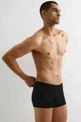 Pack de tres calzoncillos tipo trunk de color negro, confeccionados en tejido elástico con costuras planas, cintura elástica, piernas cortas y parte delantera forrada. Fabricados con tecnología Lycra® Xtra Life™.