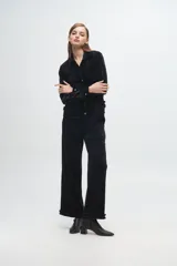 Pantalón de terciopelo con textura acanalada y destellos de lurex, de corte recto y holgado. Presenta detalle de volados en el ruedo.