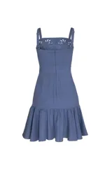 Vestido corto de lino color azul marino, con tirantes y escote cuadrado. Presenta bordados florales en tono sobre tono con aberturas caladas en el pecho y en el volado del ruedo.