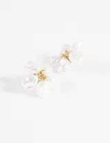 Aros colgantes con forma de flor, adornados con perlas irregulares y detalles dorados.