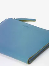 Sobre de símil cuero con efecto floater, color celeste, de diseño pequeño y liviano. Cuenta con forro de algodón, pequeño bolsillo interior y sistema de apertura con cierre metálico.