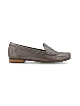 Mocasín de cuero color plomo, con diseño clásico de líneas simples, costuras pespunteadas en el empeine y detalle de remache metálico con logo en el lateral.