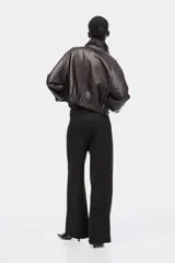 Pantalón de punto de corte holgado y tiro alto con elástico oculto en la cintura, piernas amplias con pinzas y bolsillos al bies.