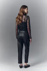 Pantalon de corte recto confeccionado en cuero ovino con acabado metalizado en color plata. Presenta cierre frontal con cremallera y bolsillos laterales.