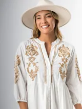 Vestido corto blanco de algodón italiano con bordado azul, mangas tres cuartos y botones frontales. Tiene forro interior en la falda.