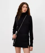 Blusa de punto básica color negro, con cuello alto y manga larga. Confeccionada en una mezcla de viscosa, poliéster y poliamida, ofrece un ajuste cómodo y versátil.