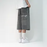 Bermuda de jean estilo baggy en color negro lavado, con corte holgado y largo por debajo de la rodilla. Presenta bolsillos traseros amplios con un bordado en hilo blanco.